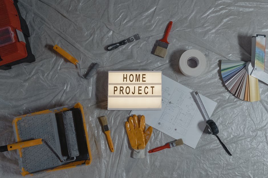 Image of carpentry tools including a saw, tape measure, pencil, and level